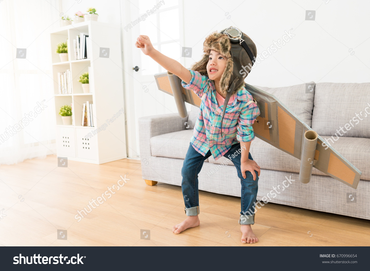 stock-photo-smiling-sweet-female-children-wearing-astronaut-costume-making-ready-to-fly-gesture-standing-on-670996654